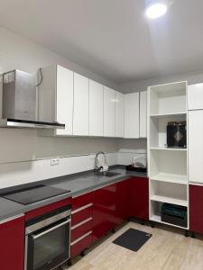 a kitchen with red and white cabinets and a sink at Casa San Pedro in San Pedro del Pinatar +11 photos