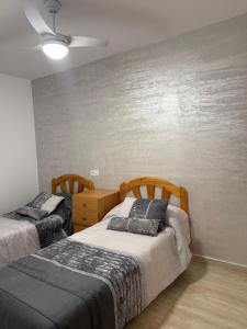 a bedroom with two beds and a wall at Casa San Pedro in San Pedro del Pinatar