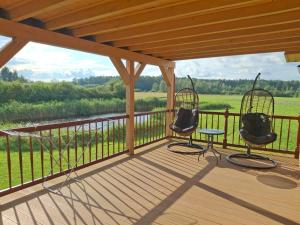 two chairs on a deck with a view of a river at Domek Apartament Windyki in Iława