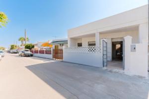 a white building with a gate on a street at Villino La conchiglia sul mare in Isola della Malva