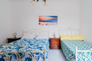 a bedroom with two beds and a painting on the wall at Villino La conchiglia sul mare in Isola della Malva