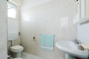 a white bathroom with a toilet and a sink at Villino La conchiglia sul mare in Isola della Malva +22 photos