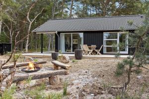 a tiny house with a fire pit in front of it at 2309-Stege-Enebaerstien-39 in Stege