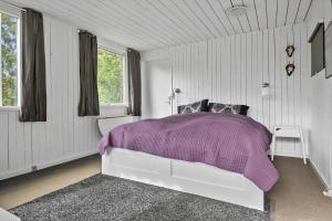 a bedroom with a white bed with a purple blanket at 8174-Praesto-Vagtelvej-14 in Præstø