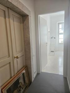 Una habitación con una puerta y un pasillo con una escalera. en GardaInn Palazzo Nuovo, en Arco 47 fotos más