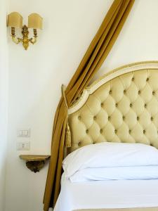 a bedroom with a bed with a gold headboard at DONNA LUCREZIA b&b Boutique Hotel Style - RELAX & BUSINESS STAY in Bisceglie +147 photos