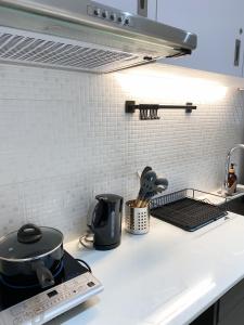 eine Küchentheke mit Töpfen und Pfannen darauf in der Unterkunft Cozy Room with Free Pool Access & PS4 Located at QC - Luxx Haven in Manila