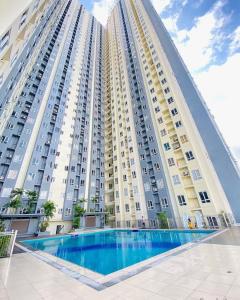 ein großes Gebäude mit einem Swimmingpool davor in der Unterkunft Cozy Room with Free Pool Access & PS4 Located at QC - Luxx Haven in Manila