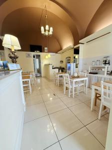 a dining room with white tables and chairs at DONNA LUCREZIA b&b Boutique Hotel Style - RELAX & BUSINESS STAY in Bisceglie