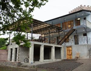 a house with a balcony and a staircase at NISS House in Akhaltsikhe