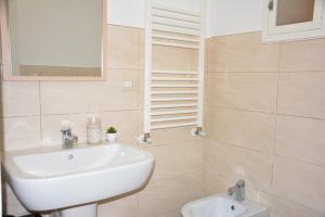 a bathroom with a white sink and a mirror at Carpe Diem Matera in Matera