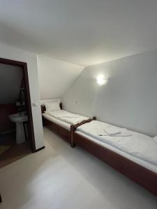 two beds in a small room with a bathroom at Pensiunea Pe drumuri de munte in Borca +15 photos