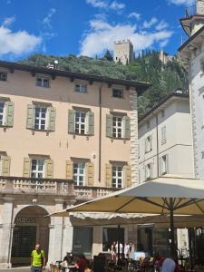 un gran edificio con una sombrilla delante de él en GardaInn Palazzo Nuovo, en Arco