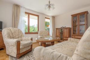 a living room with a couch and two chairs and a table at Apartments Ivana in Bled