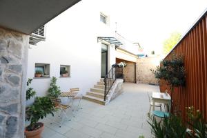 a patio with chairs and tables and a staircase at Marko&Luka in Sinj