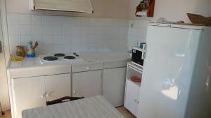 a white kitchen with a stove and a refrigerator at Les Fabres in Vernon