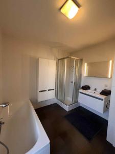 a large bathroom with a tub and a sink at L' Appart de Grand-Mère in Oudenburg