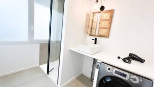 a bathroom with a washing machine and a sink at Albatros in Saint-Nazaire +28 photos