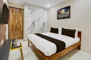 Un dormitorio con una cama grande con marco de madera. en Hotel O Amazing House, en Nueva Delhi