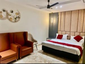 a bedroom with a bed and a chair at Hotel Chelsea Plaza in Alīgarh