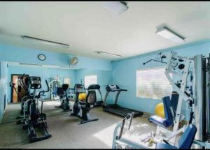 een fitnessruimte met verschillende loopvlakken in een blauwe kamer bij Casa Club Condo in Tucson