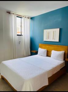 a blue bedroom with a large bed with white sheets at Monte vista in Sosúa