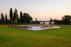 a pool with a bunch of chairs in a field at Memories Residence in Petroúlai