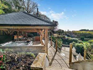 a hot tub in a gazebo in a garden at Rose Cottage in Saint Hilary