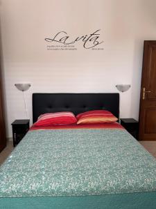 a bed with two red pillows in a bedroom at Domo Mea in Cardedu +2 photos