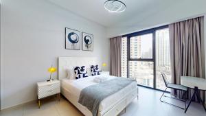 biała sypialnia z łóżkiem i dużym oknem w obiekcie Act One Act Two - Two Bedroom in Vibrant Downtown w Dubaju +18 zdjęć