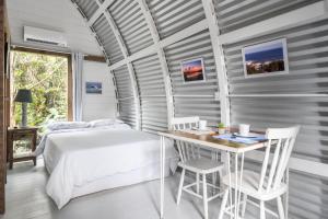 a bedroom with a bed and a table and chairs at Micro Casa Gótica in Florianópolis +5 photos