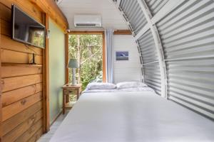 a couple of beds in a room with a window at Micro Casa Gótica in Florianópolis