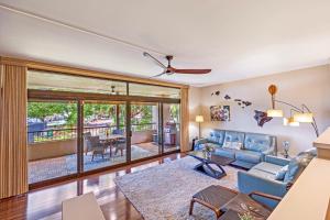 Una sala de estar con un sofá azul y una mesa. en Kaanapali Royal Q-202, en Lahaina