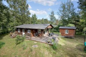 a small cabin with a deck in a field at 2002-Stege-Solvgranen-7 in Stege