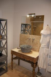 uma casa de banho com um lavatório e um espelho em Appart'hôtel 27 le lion d'or em Malaucène