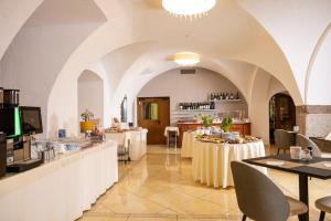 a restaurant with tables and chairs in a room at Hotel Posta in Comano Terme