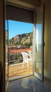 an open door to a balcony with a bench on a deck at Delle Rose in Cefalù