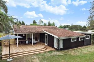 a black house with a deck and an umbrella at 1102-Stege-Rylevej-24 in Stege +16 photos