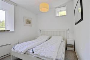 a white bedroom with a bed with white sheets at 4304-Borre-Klintevej-273 in Borre