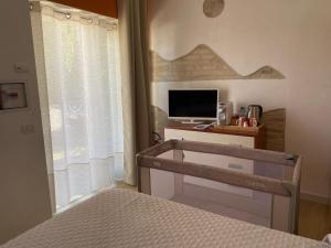 a bedroom with a bed and a desk with a television at Le Pervinche Affittacamere in Bastia Umbra