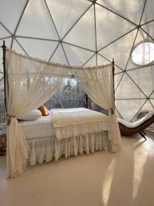 EatontonにあるBeloved Cabin - Zen Retreat Domeのテント内のベッドルーム1室(天蓋付きベッド1台付) +8枚の写真