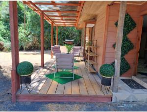 a porch of a house with chairs and plants at Cabañas Torres Del Bosque in Pucón