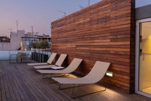 a row of chairs sitting on a wooden deck at Mercer House Bòria BCN in Barcelona