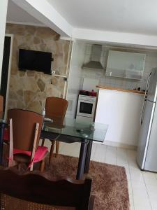 Una cocina con mesa y sillas y un refrigerador. en La maison du bonheur, en Fort-de-France