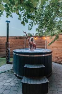 a woman in a hot tub in a backyard at Przystanek Roztocze- leśne SPA, Jacuzzi & sauna in Susiec