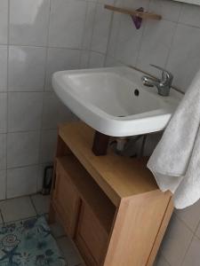 baño con lavabo blanco en un soporte de madera en La maison du bonheur, en Fort-de-France