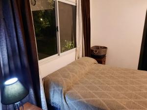 a bedroom with a bed and a window at CASA DE CAMPO barrio privado Salta in Cerrillos