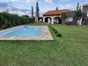 a yard with a swimming pool and a house at CASA DE CAMPO barrio privado Salta in Cerrillos +11 photos