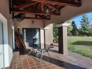 a patio with a glass table on a house at CASA DE CAMPO barrio privado Salta in Cerrillos