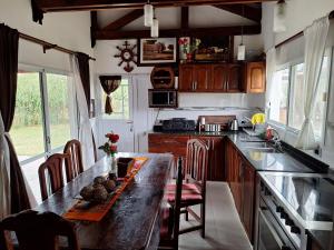 a kitchen with a counter and a table with chairs at CASA DE CAMPO barrio privado Salta in Cerrillos